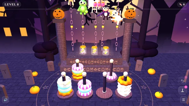Free online Halloween ring sorting puzzle with glowing rings on poles in a haunted graveyard and silly monsters